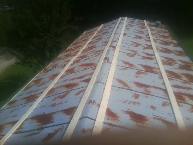 Rusted metal roof panels with new wood purlins before replacement — Storm Damage Roof Repair in Searcy by Roofing Brothers
